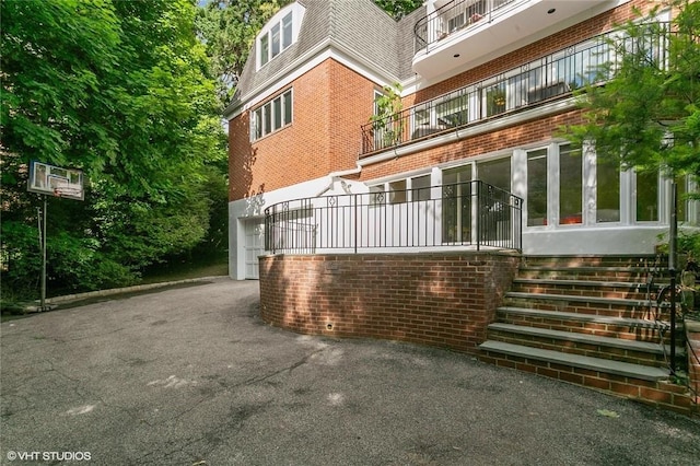 30 Appleton Pl, Dobbs Ferry, NY 10522 - exterior space with brick siding, mansard roof, a balcony, driveway, and an attached garage
