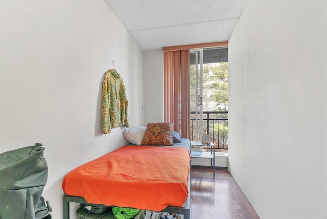 bedroom with a textured ceiling and wood finished floors