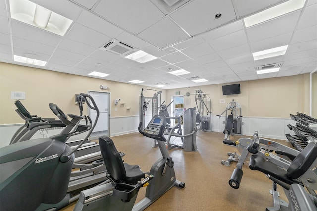 gym with baseboards, visible vents, and a drop ceiling