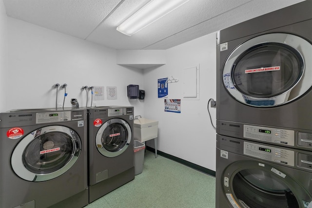 shared laundry area featuring stacked washer / dryer, washing machine and dryer, and baseboards