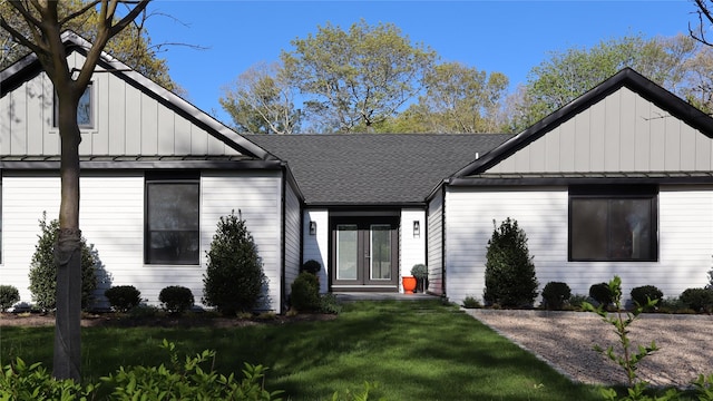 10 Hampton St, Westhampton Beach, NY 11978 - view of front facade with board and batten siding, a standing seam roof, a shingled roof, and a front yard