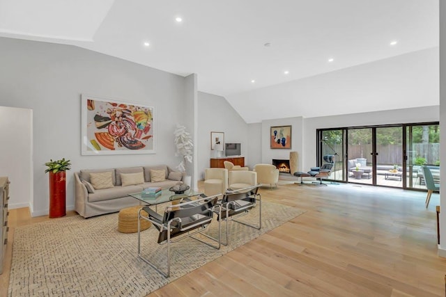 10 Hampton St, Westhampton Beach, NY 11978 - living area with a warm lit fireplace, light wood finished floors, recessed lighting, high vaulted ceiling, and baseboards