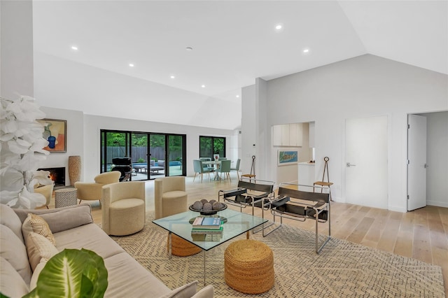 10 Hampton St, Westhampton Beach, NY 11978 - living area with light wood-type flooring, high vaulted ceiling, recessed lighting, and a warm lit fireplace