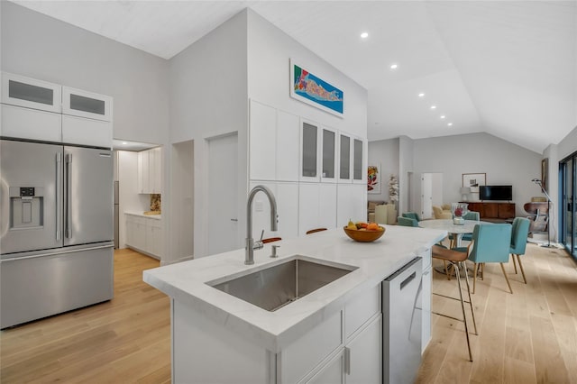 10 Hampton St, Westhampton Beach, NY 11978 - kitchen featuring appliances with stainless steel finishes, a sink, light wood-type flooring, white cabinetry, and light stone countertops
