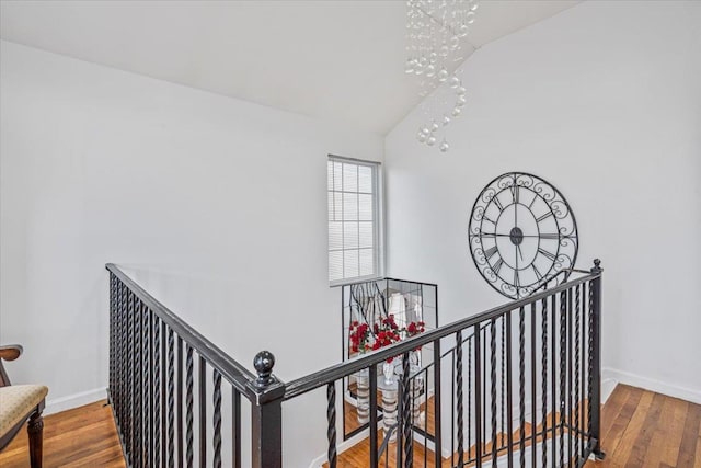 stairs with baseboards, vaulted ceiling, and wood finished floors