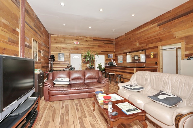 living area with recessed lighting, wooden walls, and wood finished floors