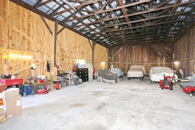 misc room with concrete flooring, lofted ceiling, and a garage