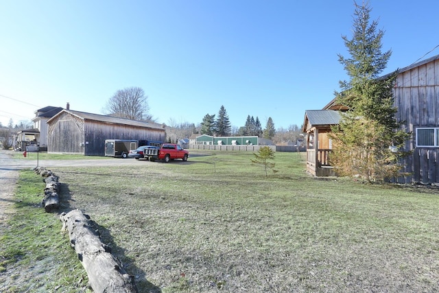 view of yard featuring an outbuilding and fence