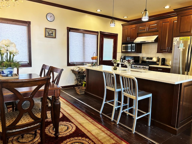 300 Ellen Pl, Oyster Bay, NY 11753 - kitchen with pendant lighting, appliances with stainless steel finishes, dark wood finished floors, light countertops, and under cabinet range hood