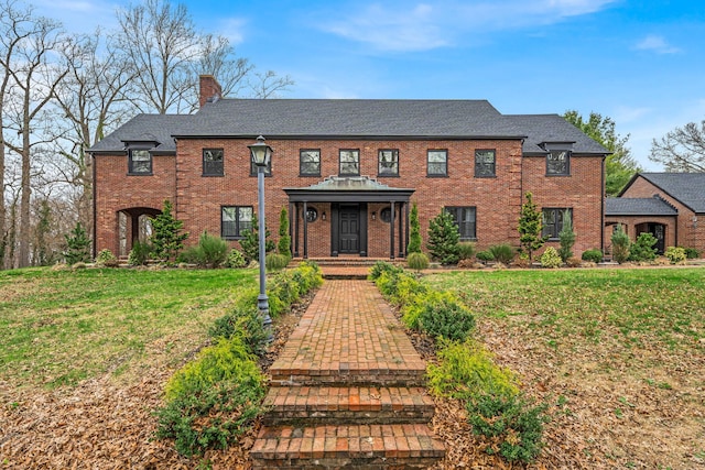 28 Northfield Rd, Glen Cove, NY 11542 - view of front facade with brick siding, roof with shingles, a chimney, and a front yard