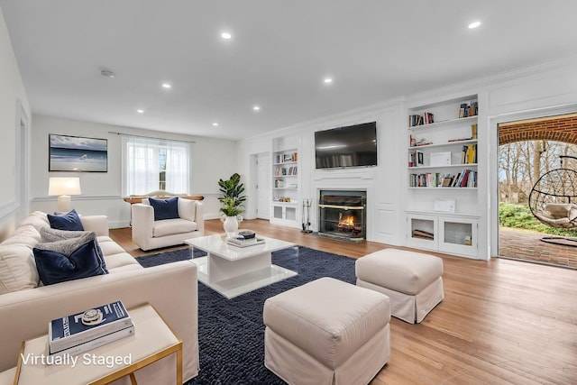 28 Northfield Rd, Glen Cove, NY 11542 - living room with built in features, recessed lighting, a glass covered fireplace, and light wood-style floors