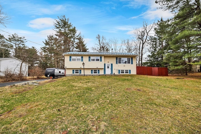split foyer home with fence, a front yard, and metal roof