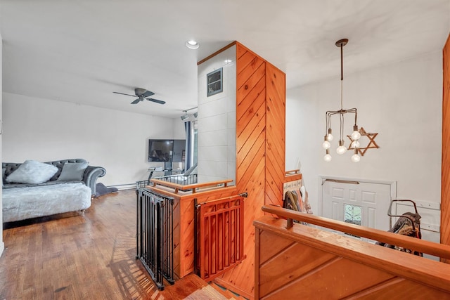 interior space featuring ceiling fan with notable chandelier, wood finished floors, and recessed lighting