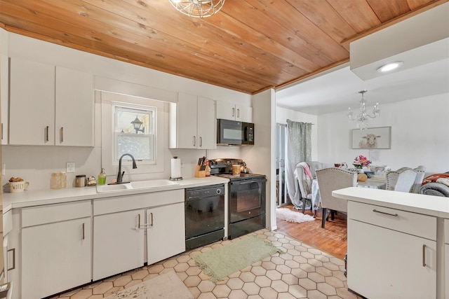 kitchen with a sink, black appliances, wood ceiling, light countertops, and white cabinets