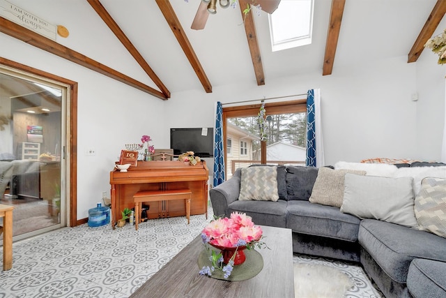 living area with ceiling fan, baseboards, and lofted ceiling with skylight