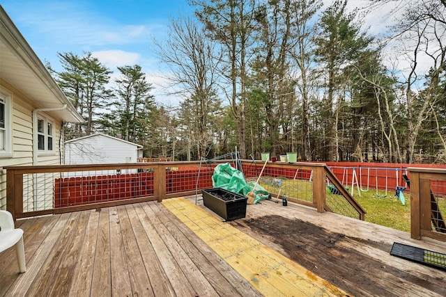 wooden deck featuring a fenced backyard and a fire pit