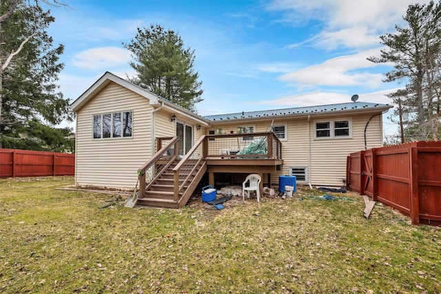 back of house with metal roof, fence, a wooden deck, a lawn, and stairway