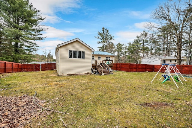 back of property featuring a wooden deck, a yard, a fenced backyard, and stairs