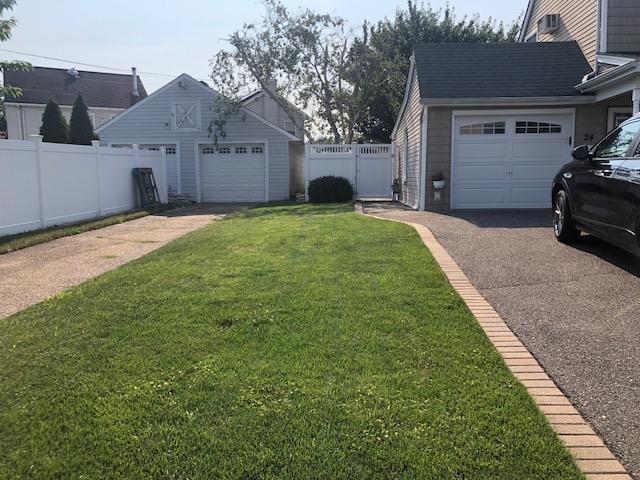 view of yard featuring fence and an outbuilding