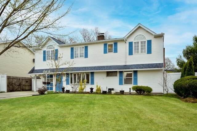63 Bucket Ln, Levittown, NY 11756 - traditional-style house with roof with shingles, a front lawn, driveway, a chimney, and fence