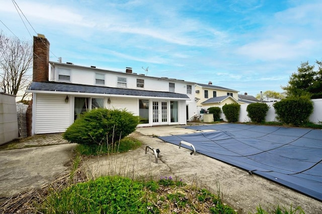 63 Bucket Ln, Levittown, NY 11756 - rear view of property with a chimney, fence, a shingled roof, and french doors