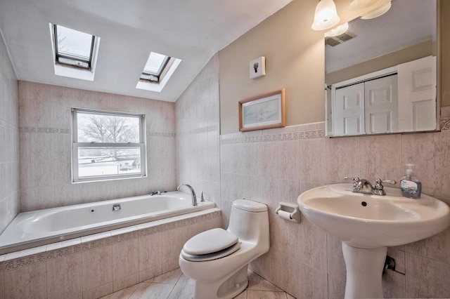 63 Bucket Ln, Levittown, NY 11756 - bathroom with tiled tub, toilet, a skylight, and tile walls