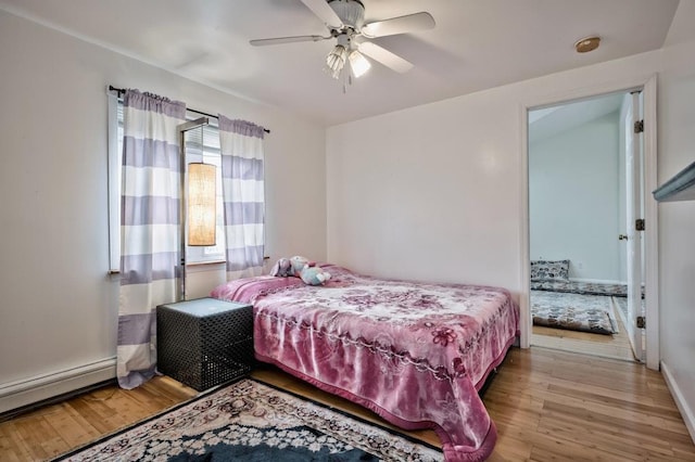 63 Bucket Ln, Levittown, NY 11756 - bedroom with a baseboard radiator, a ceiling fan, and wood finished floors
