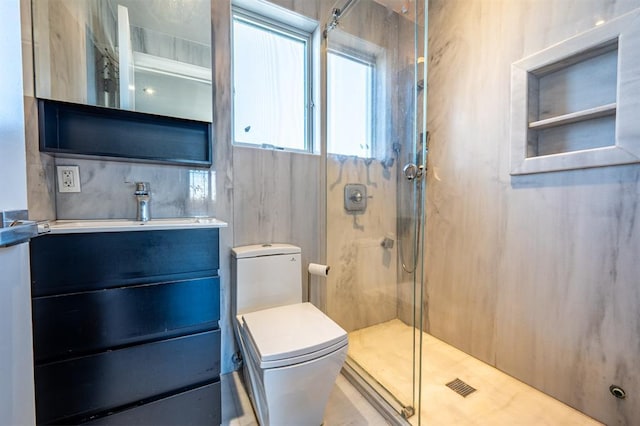 bathroom featuring toilet, vanity, and a shower stall