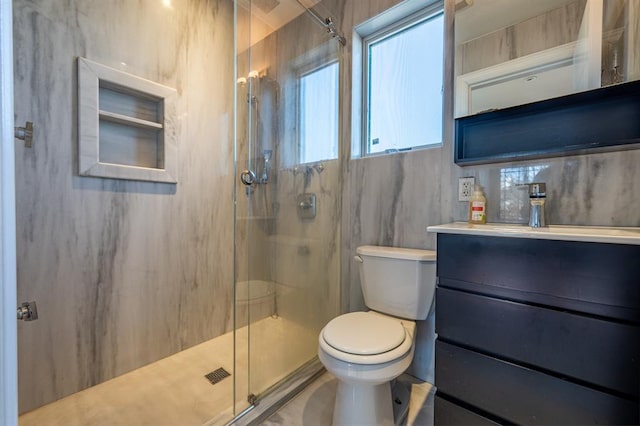 full bathroom featuring toilet, vanity, and a marble finish shower