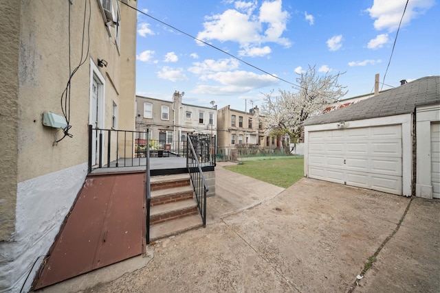 87 E 32nd St, Brooklyn, NY 11226 - view of patio with concrete driveway, an outbuilding, a residential view, and a garage