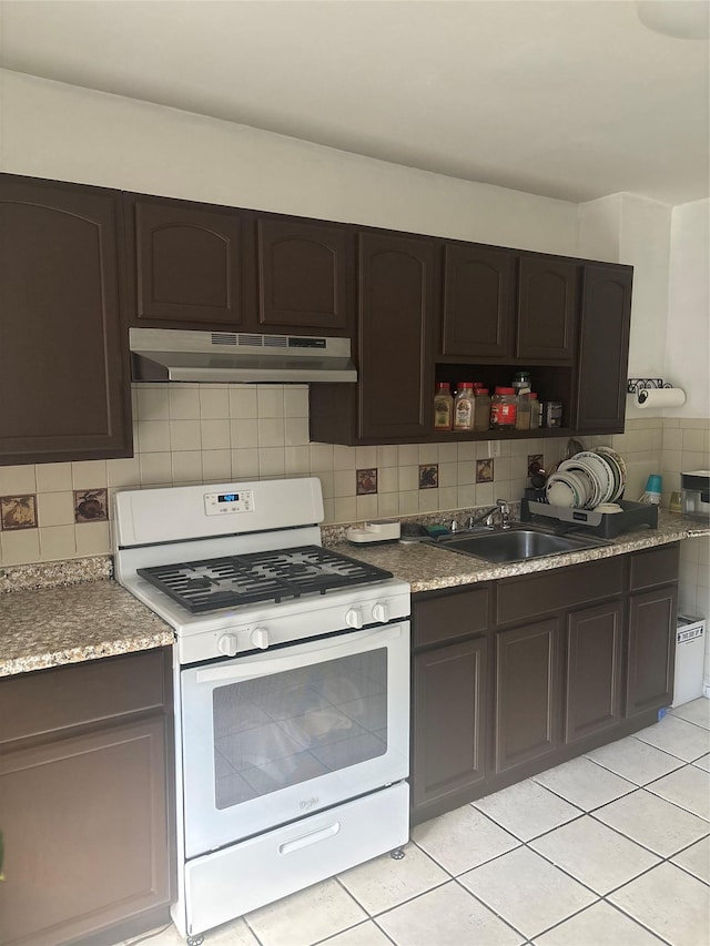 438 Shepherd Ave, Brooklyn, NY 11208 - kitchen featuring white gas range, under cabinet range hood, a sink, and light tile patterned flooring