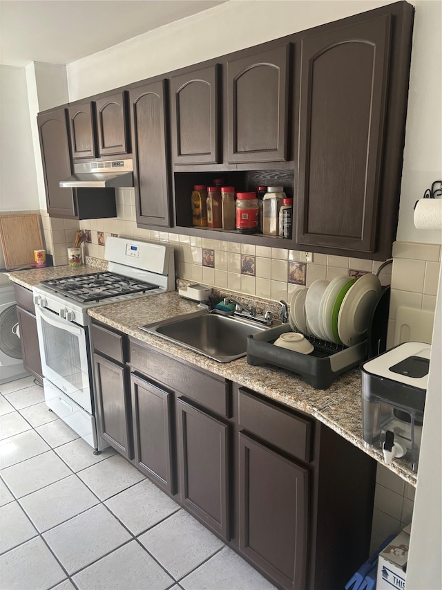 438 Shepherd Ave, Brooklyn, NY 11208 - kitchen with gas range gas stove, under cabinet range hood, a sink, tasteful backsplash, and light tile patterned floors