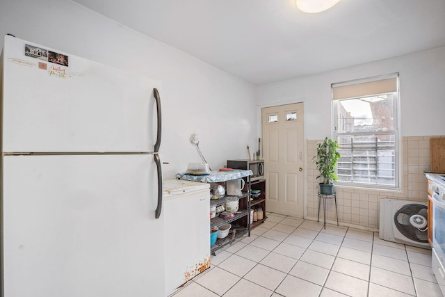 438 Shepherd Ave, Brooklyn, NY 11208 - kitchen with freestanding refrigerator, washer / dryer, stainless steel microwave, light tile patterned flooring, and tile walls