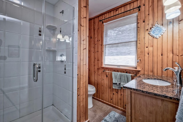 full bathroom featuring wooden walls, toilet, vanity, and a stall shower