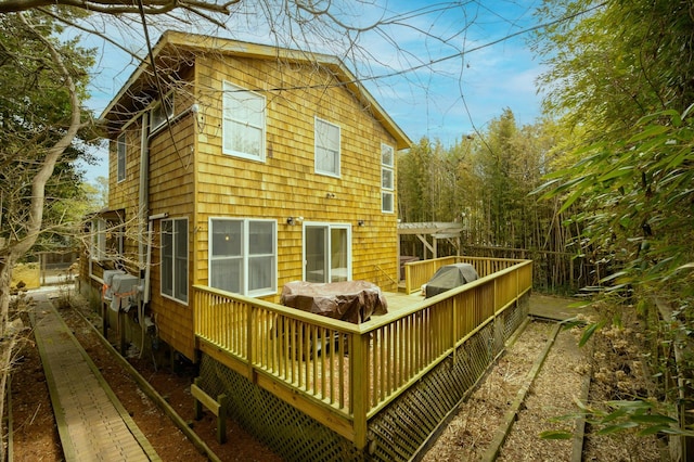 back of property featuring a pergola and a deck