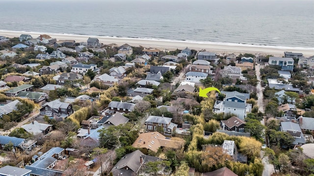 drone / aerial view with a water view, a beach view, and a residential view