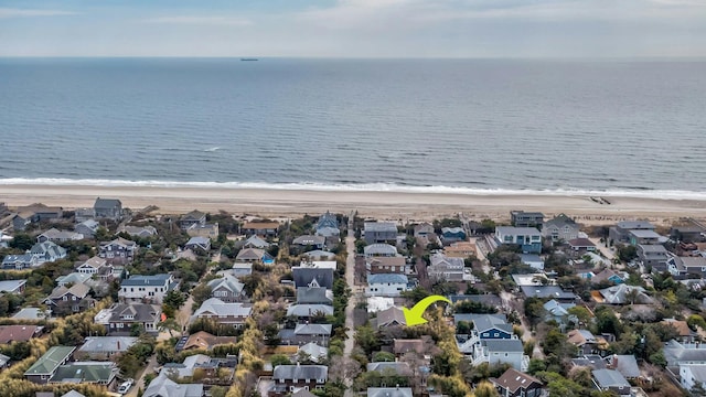 drone / aerial view featuring a water view, a residential view, and a beach view
