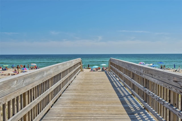 view of community featuring a water view and a beach view