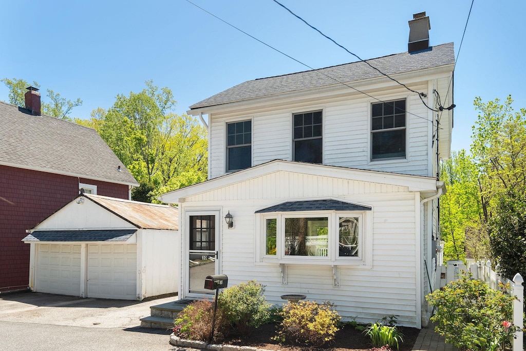 30 Requa St, Briarcliff Manor, NY 10510 - view of front of home featuring a garage, an outdoor structure, a chimney, and a shingled roof