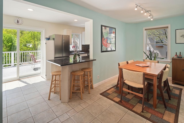 dining room featuring track lighting, baseboards, recessed lighting, and light tile patterned flooring