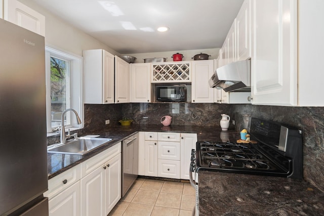 kitchen featuring white cabinets, light tile patterned flooring, appliances with stainless steel finishes, a sink, and under cabinet range hood