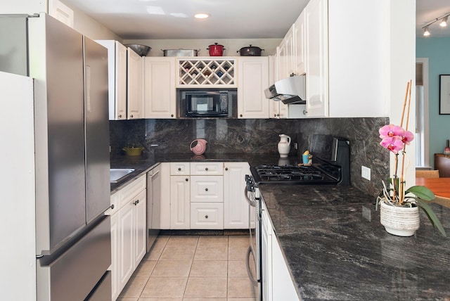 kitchen with white cabinets, appliances with stainless steel finishes, decorative backsplash, light tile patterned floors, and under cabinet range hood