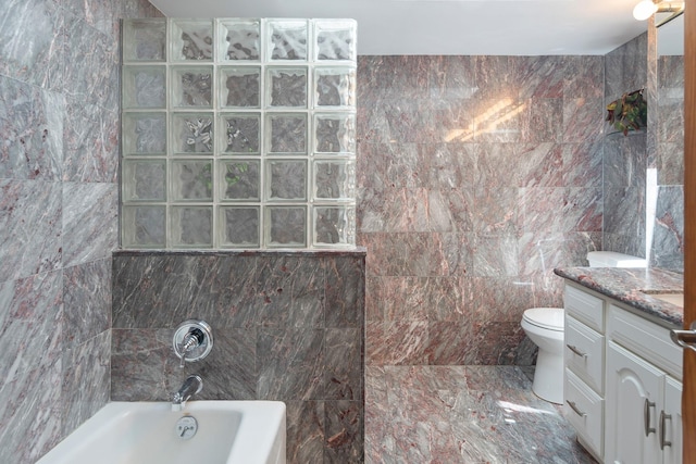 full bath featuring vanity, toilet, tile walls, and shower / washtub combination