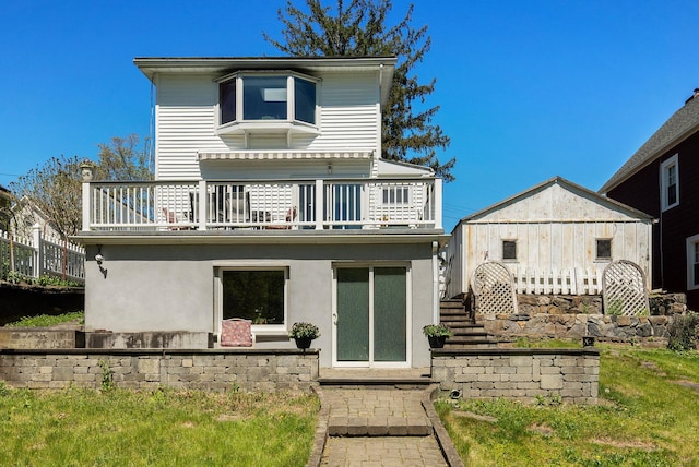 back of property featuring stairway and a balcony