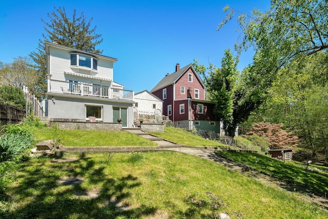 rear view of property with a lawn and stucco siding