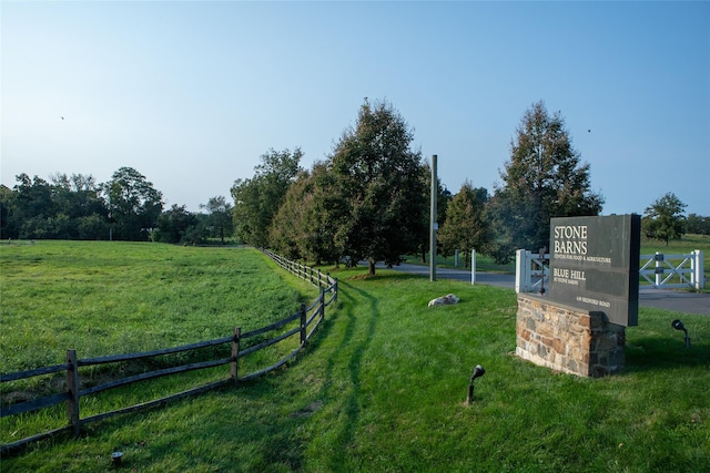 view of property's community with fence and a lawn