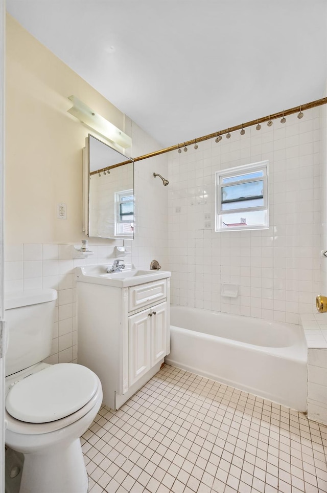 338 Hendrix St, Brooklyn, NY 11207 - full bathroom featuring tile patterned floors, toilet, vanity, tile walls, and shower / tub combination