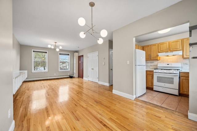 338 Hendrix St, Brooklyn, NY 11207 - kitchen featuring a baseboard radiator, a chandelier, white appliances, light wood-style floors, and under cabinet range hood