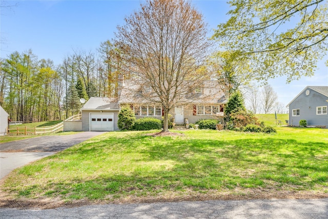 view of front of property featuring fence, a front lawn, aphalt driveway, and an attached garage