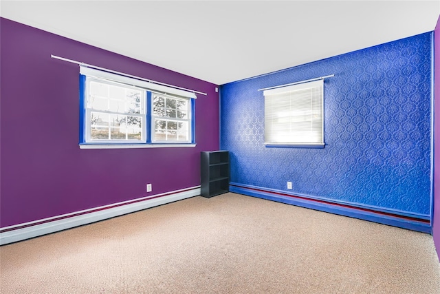carpeted spare room with baseboard heating and baseboards